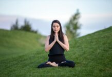 요가와 명상으로 몸과 마음 치유하기 woman in black tank top and black pants sitting on green grass field during daytime