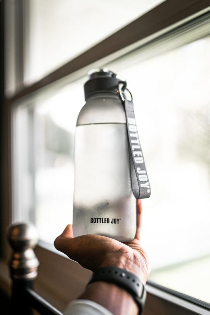 Photo by Brandon Atchison person holding gray and black tumbler