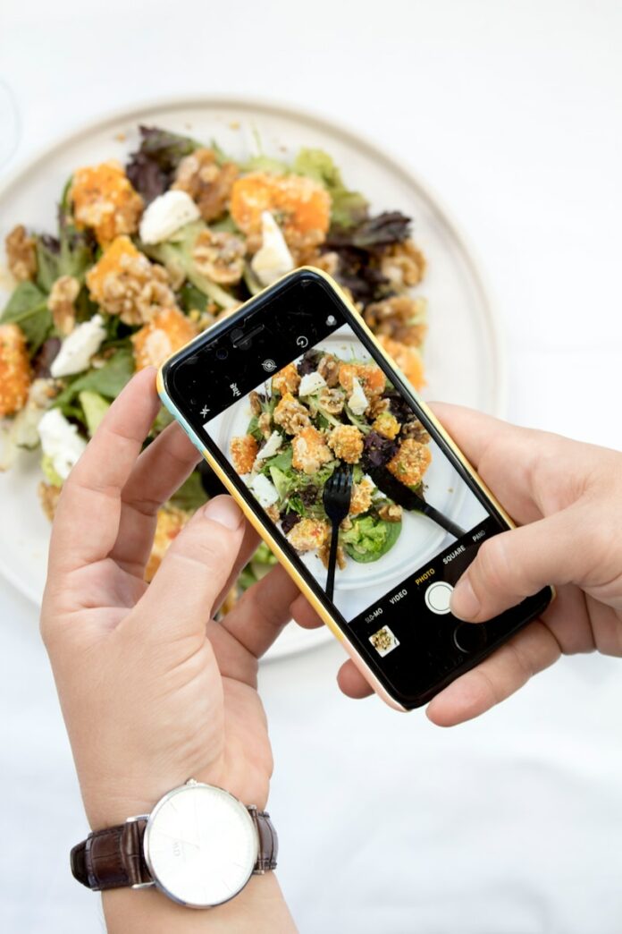 Photo by S O C I A L . C U T person using iPhone taking picture of food